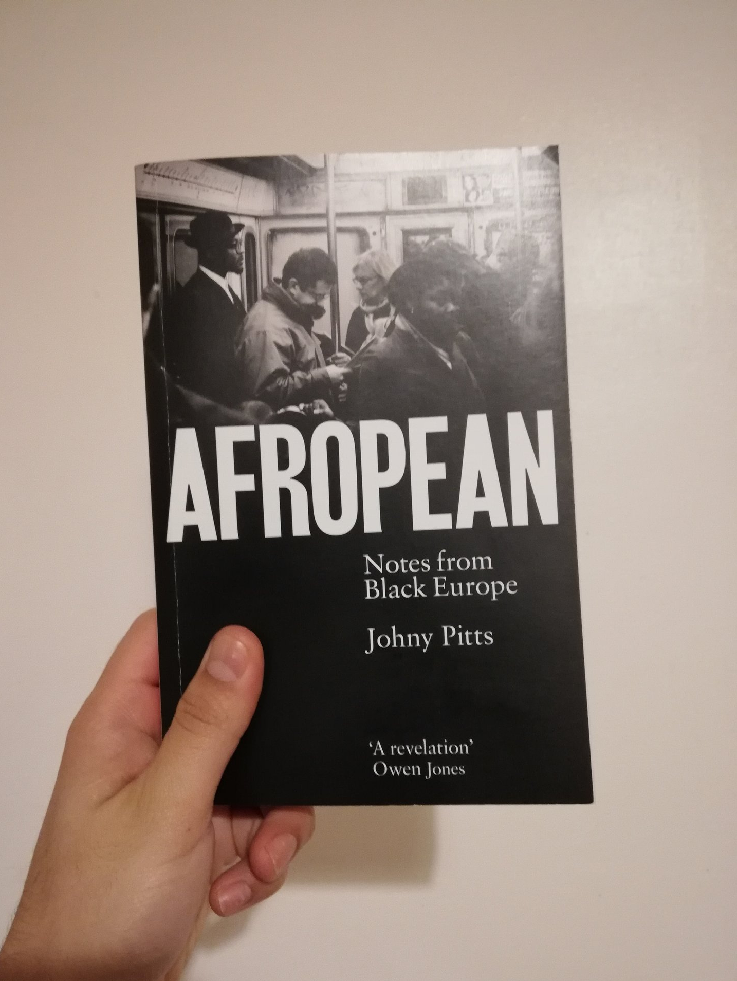 A hand holding a copy of a book, Afropean by Johny Pitts.