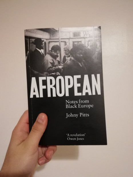 A hand holding a copy of a book, Afropean by Johny Pitts.